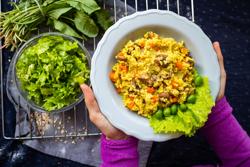 Yellow millet grain porridge with vegetables, herbs, spices and mushrooms. Vegan healthy food. Hands; Shutterstock ID 1719806515; purchase_order: -; job: -; client: -; other: -