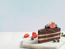 Delicious fresh chocolate cake with berries on white table. No Ardent Mills product used in this photo. 