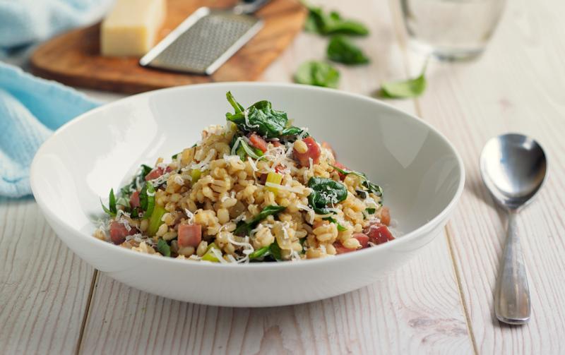 Home made pearl barley salad.tossing the barley with pesto sauce and cucumber,cherry tomatoes.service with grated parmesan cheese