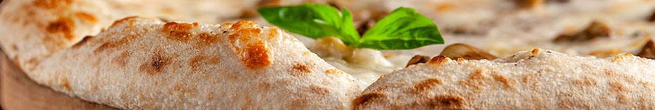 The concept of Italian cuisine. Thin cheese pizza with mushrooms, with large sides of Semola flour. A string of red wine on the table. Serving dishes in the restaurant